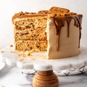 A Biscoff cookie butter cake on a white cake stand.