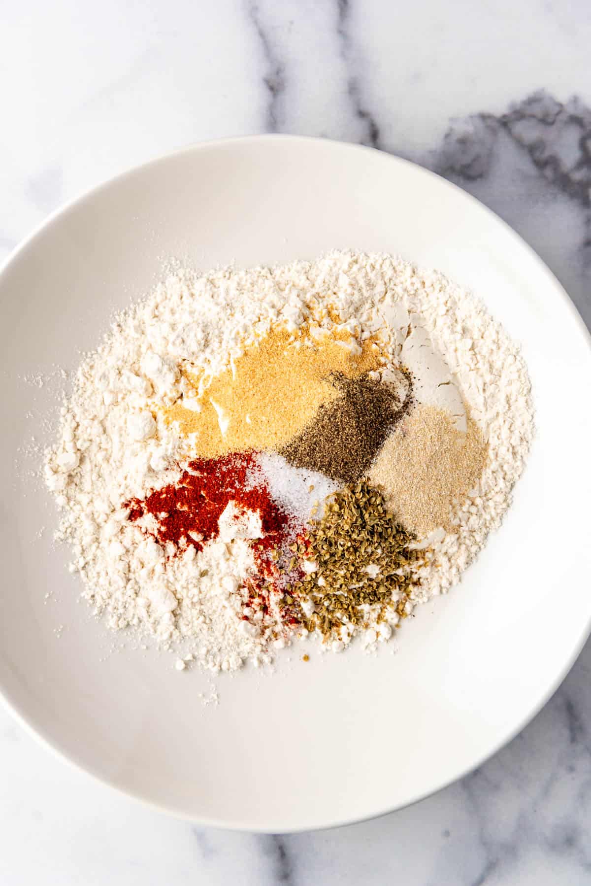 Flour and spices in a shallow bowl.