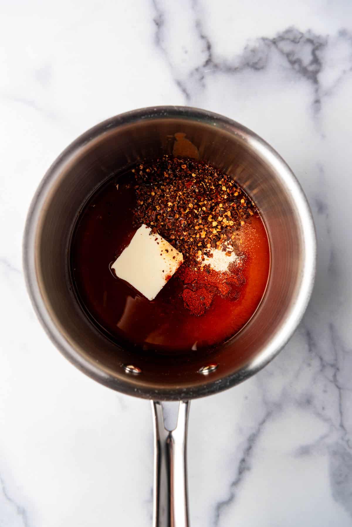 Ingredients for making homemade hot honey in a small saucepan.