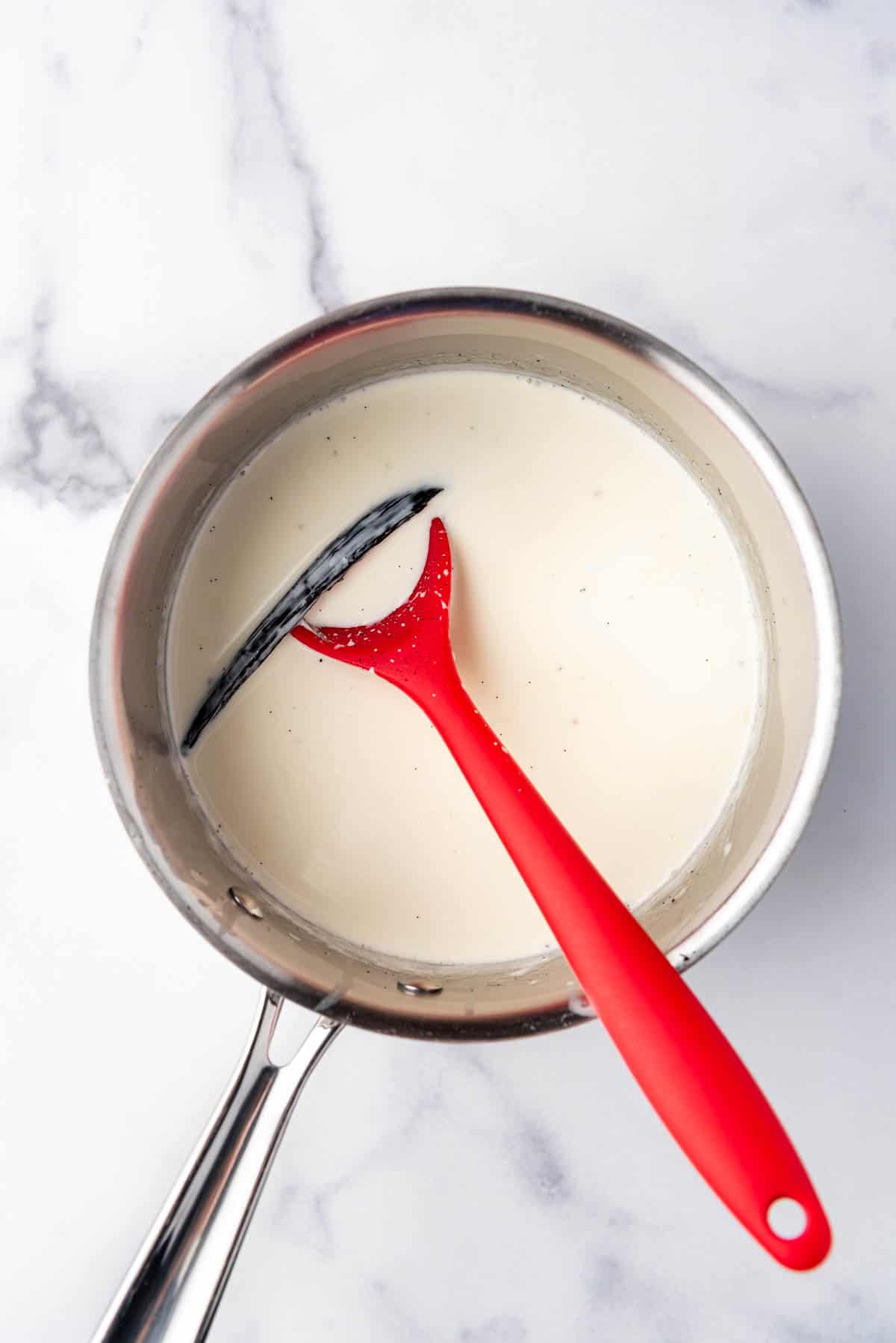 Steeping a vanilla bean in hot cream in a medium saucepan.