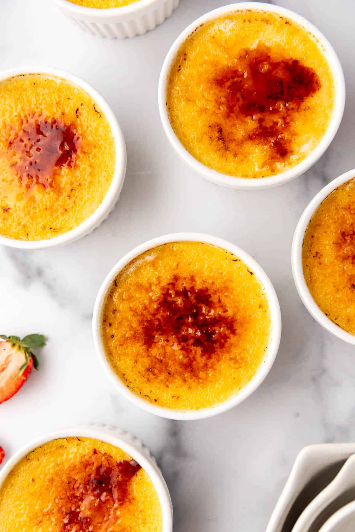 An image of individual ramekins with creme brulee with toasted sugar on top.