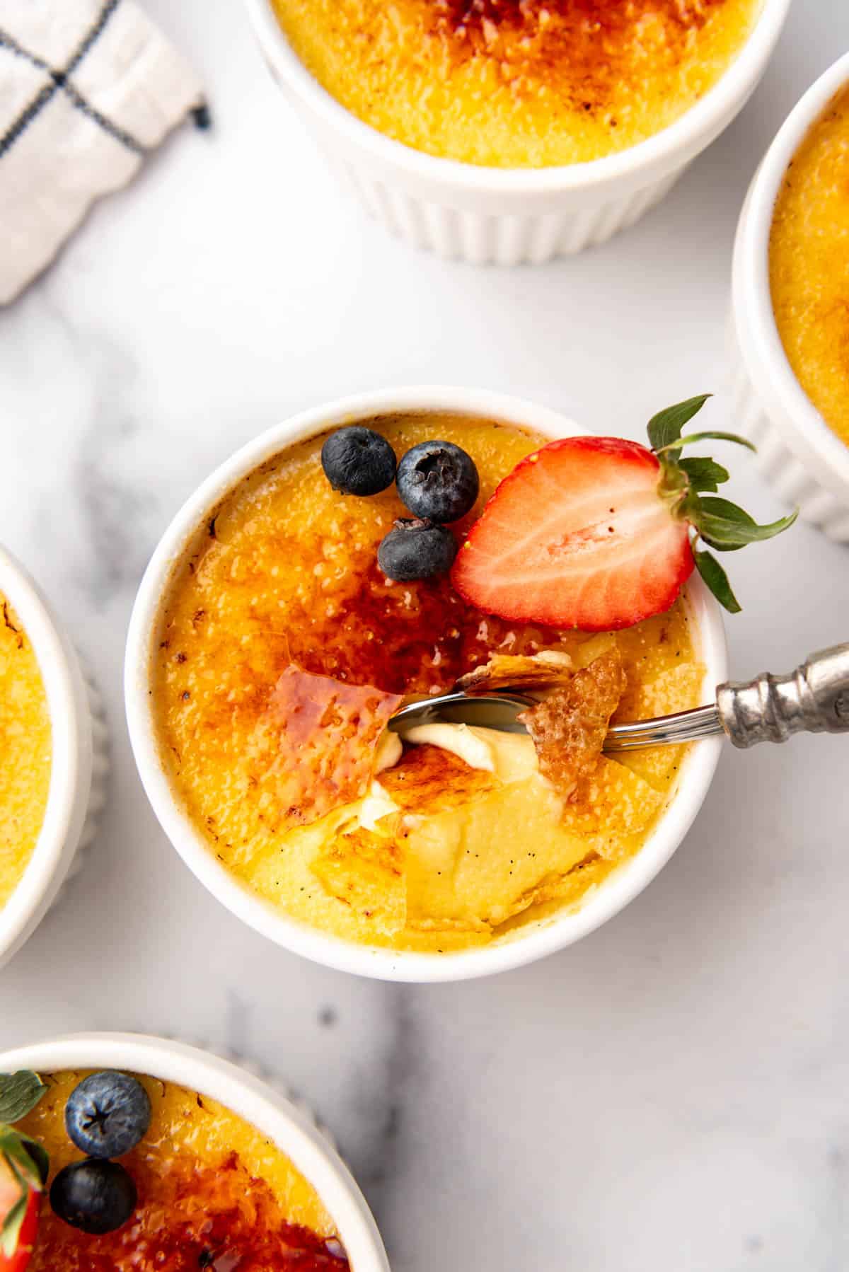 An overhead image of creme brulee with a spoon in it.