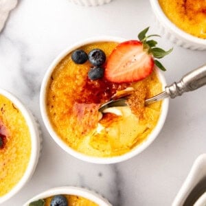 An overhead image of creme brulee with a spoon in it.