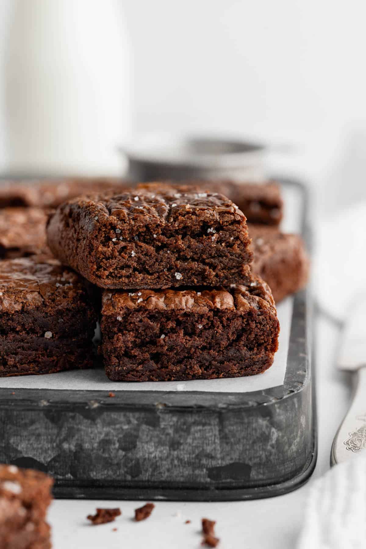 Stacked brownies on an overturned baking sheet.