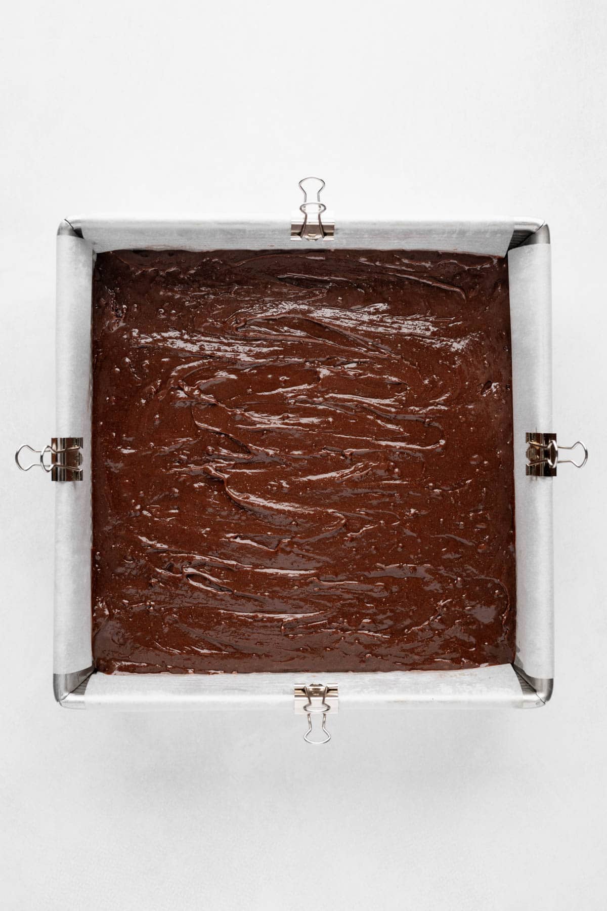 Brownie batter in a square pan.