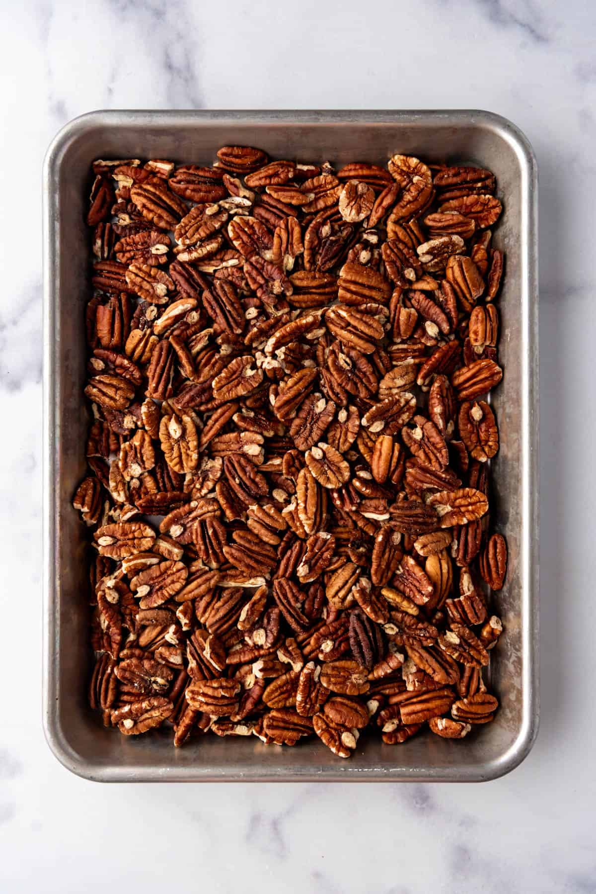 Toasting pecans on a baking sheet.