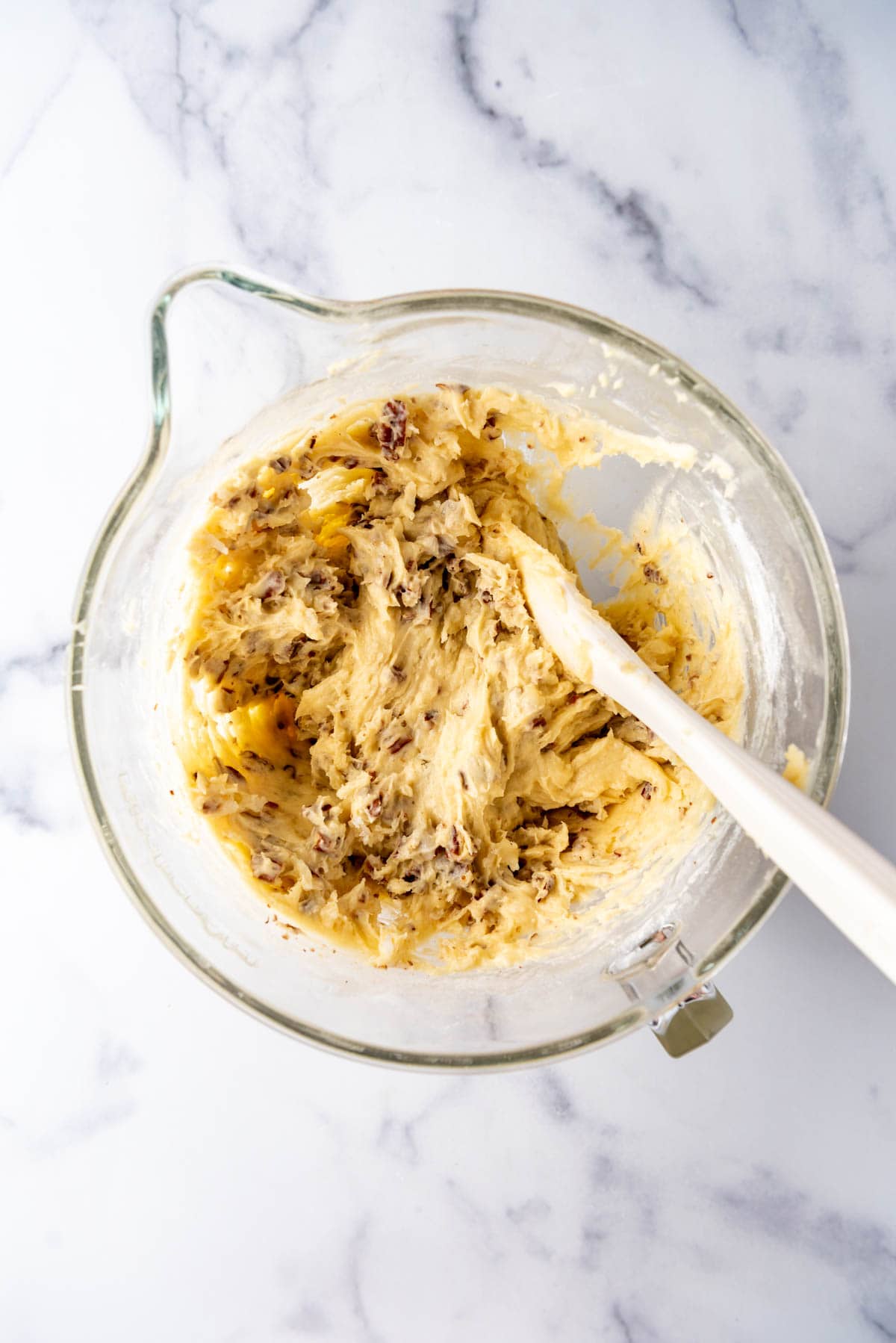 A spatula in a large mixing bowl of cake batter.