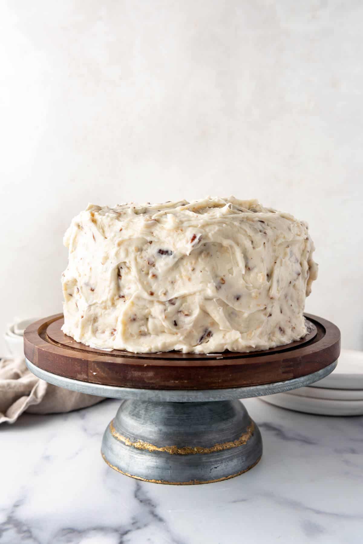 A frosted Italian cream cake on a cake stand.