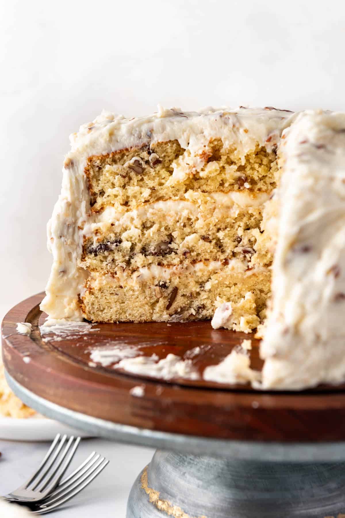 A close image of a cross section of Italian cream cake on a wooden cake stand.