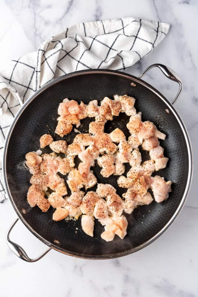 An overhead image of chicken pieces in a large pan.