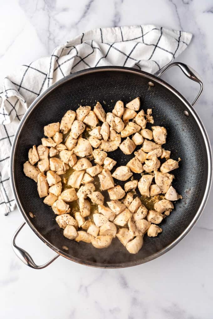 Cooked chicken pieces in a large skillet.