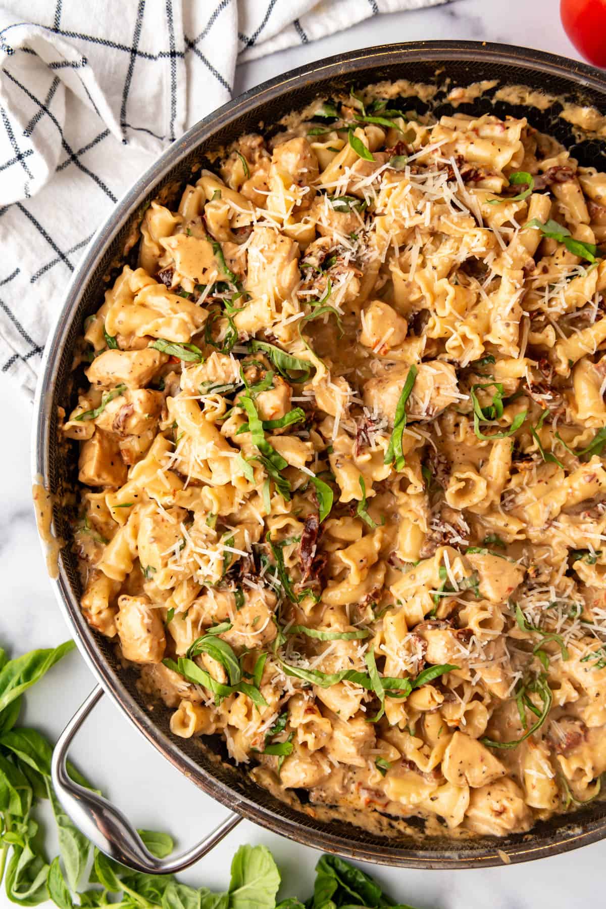 Finished marry me chicken pasta in a large pan with thin strips of fresh basil sprinkled on top.