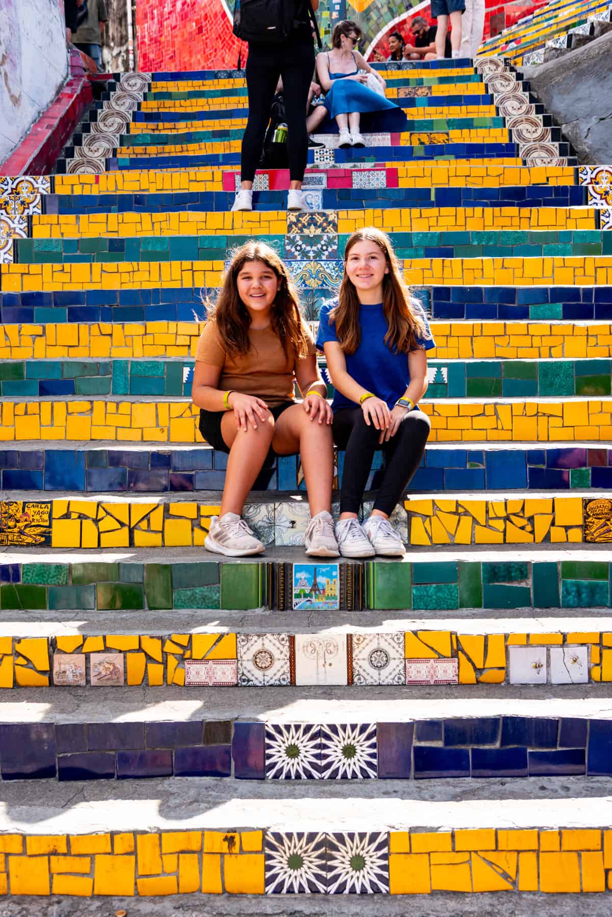 Two girls on colorful steps in Rio de Janeiro.