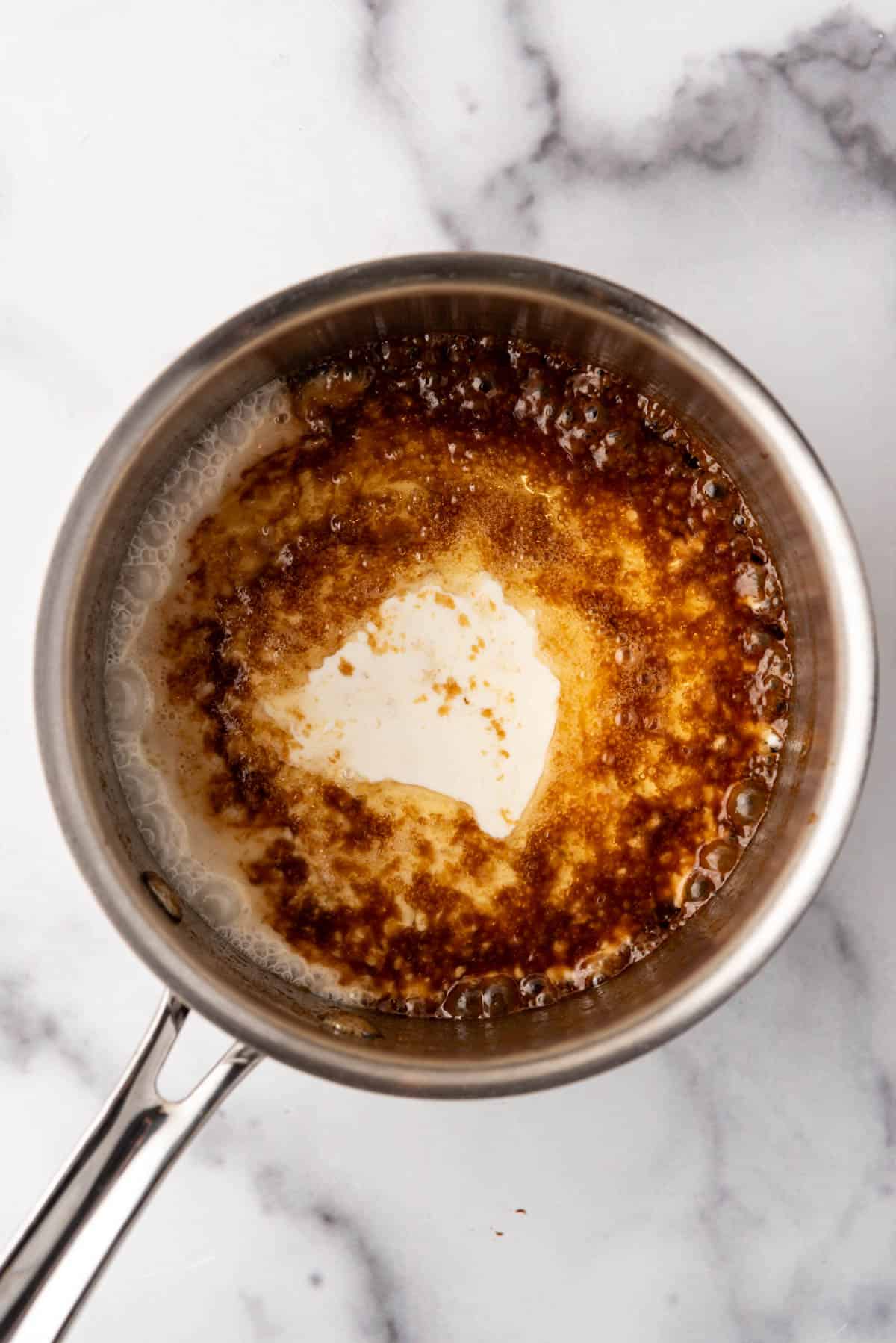 Adding heavy cream to make toffee sauce.