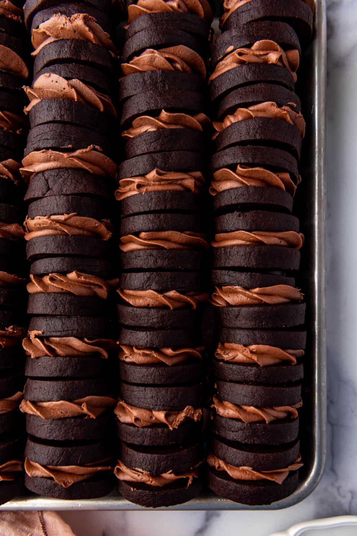 Dark chocolate nutella sandwich cookies in rows.