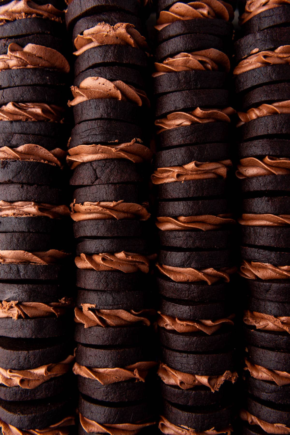 A close overhead image of swirled of Nutella ganache sandwiched between two dark chocolate shortbread cookies.