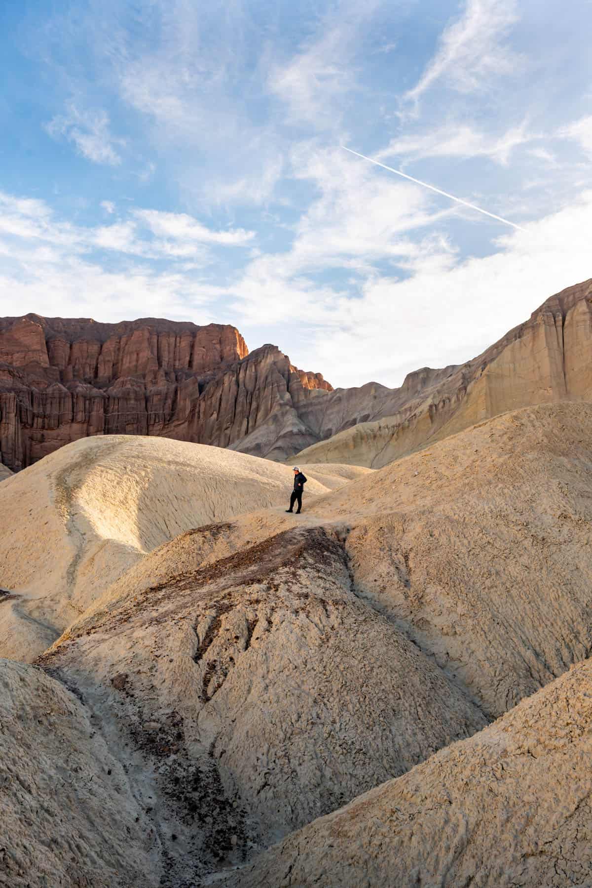 A man standing on a rock formation in Death Valley.