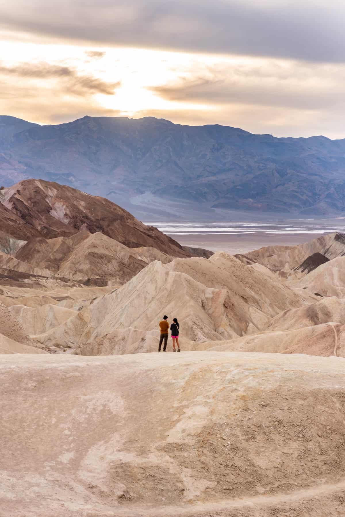 A couple looking out at the sunset at Zabriskie Point in Death Valley.