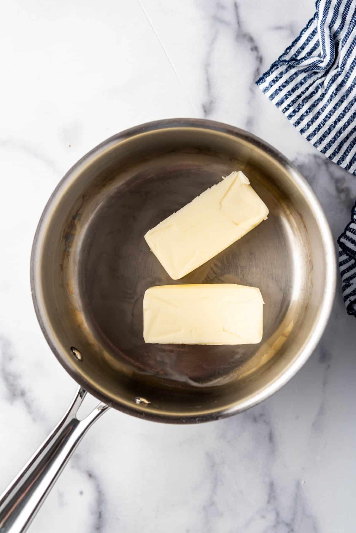 Two sticks of butter in a pan.