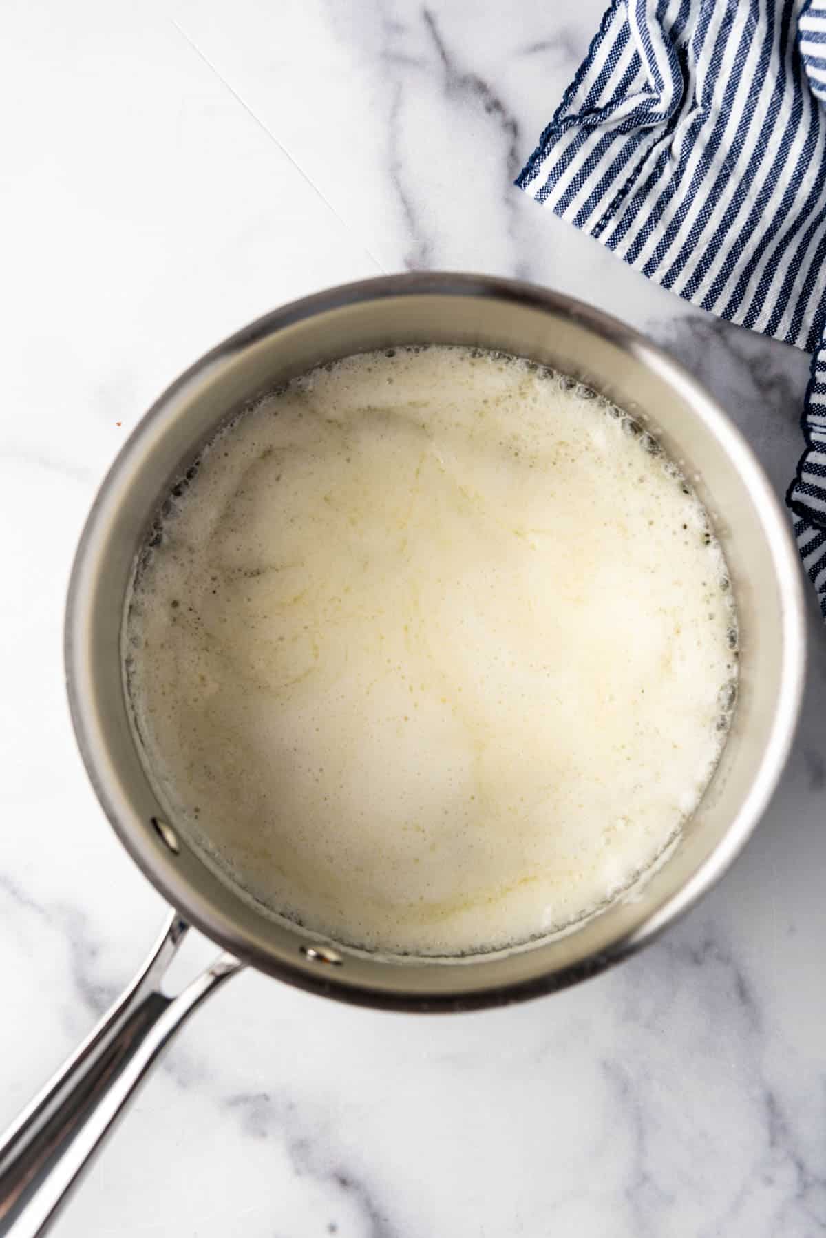 An overhead image of foaming butter in a saucepan.