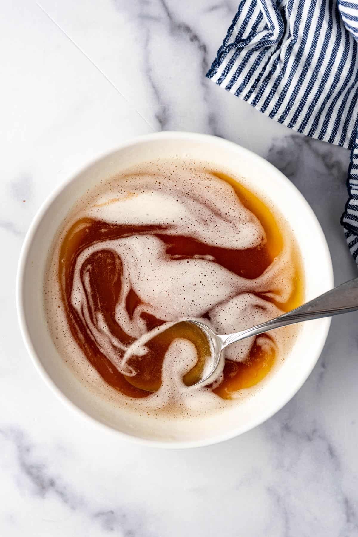 An overhead image of a bowl of brown butter with a spoon in it.