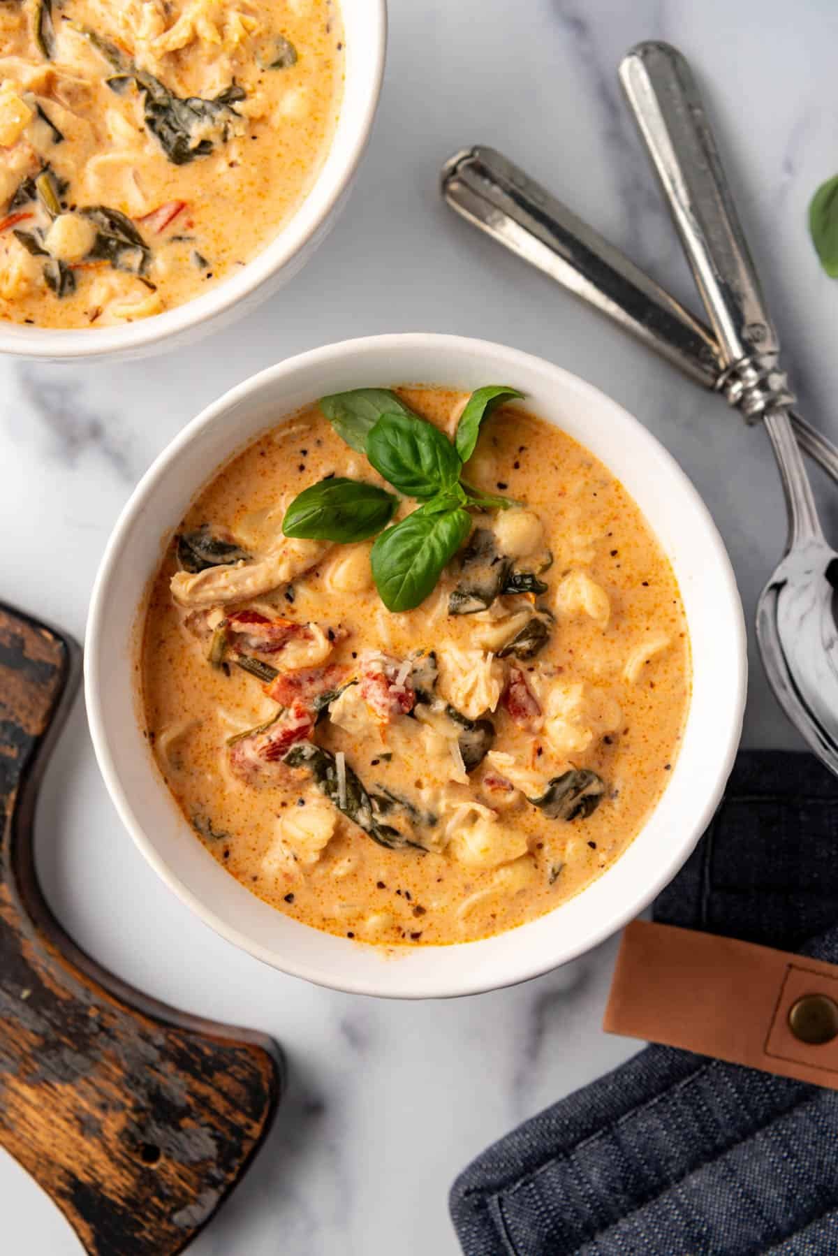 An overhead image of a bowl of  marry me chicken soup with pasta.