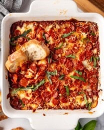 An overhead image of a white baking dish filled with pizza dip.