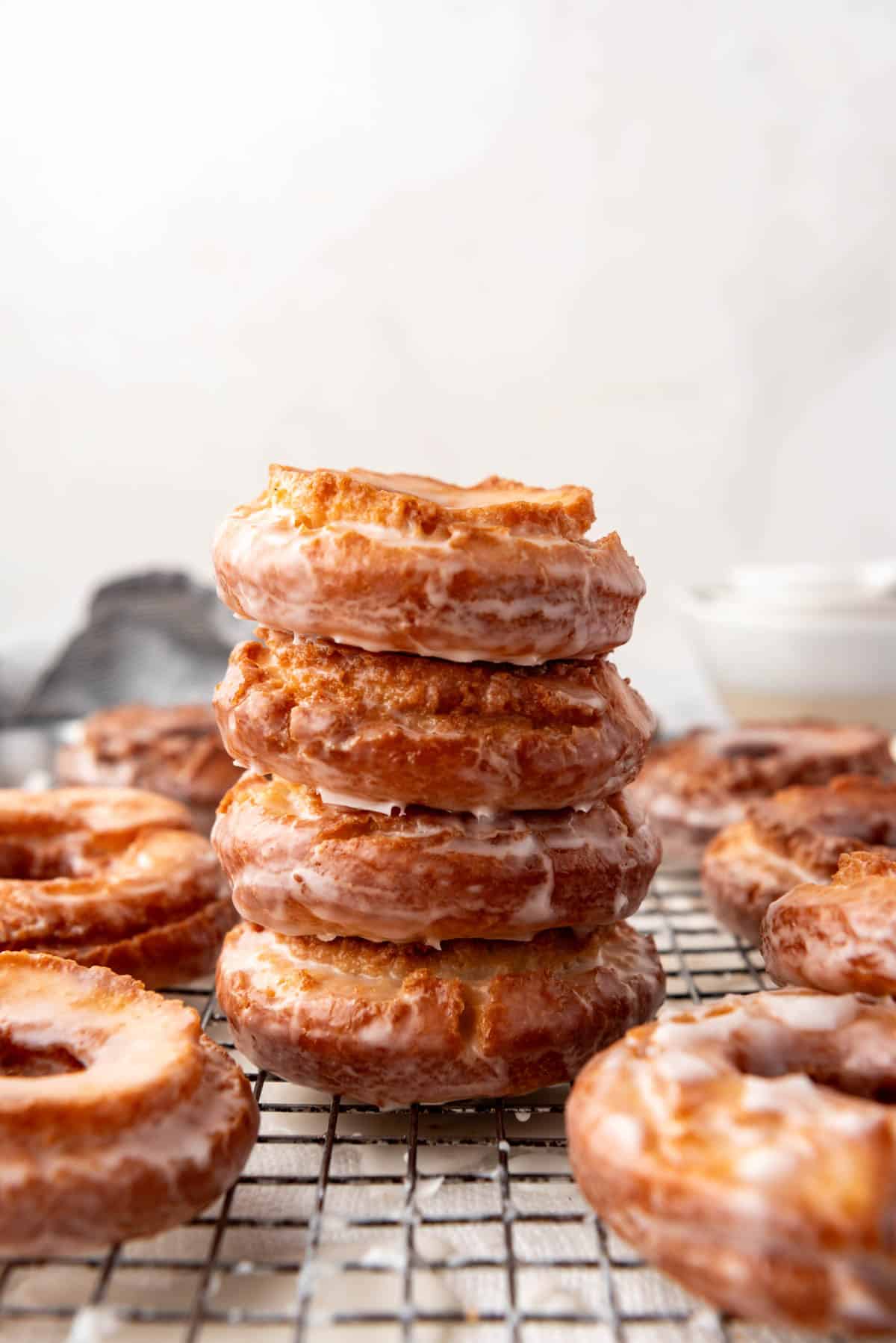 An image of glazed cake doughnuts staked on top of each other.