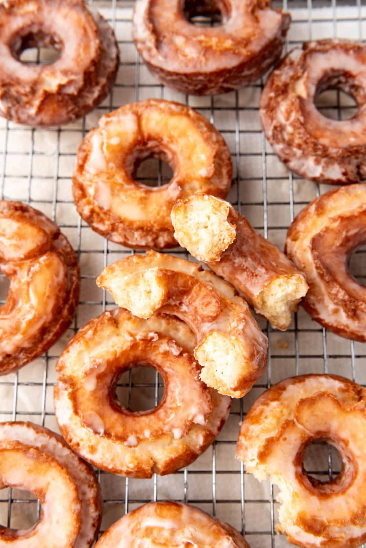 An overhead image of old-fashioned sour cream doughnuts with one broken in half.