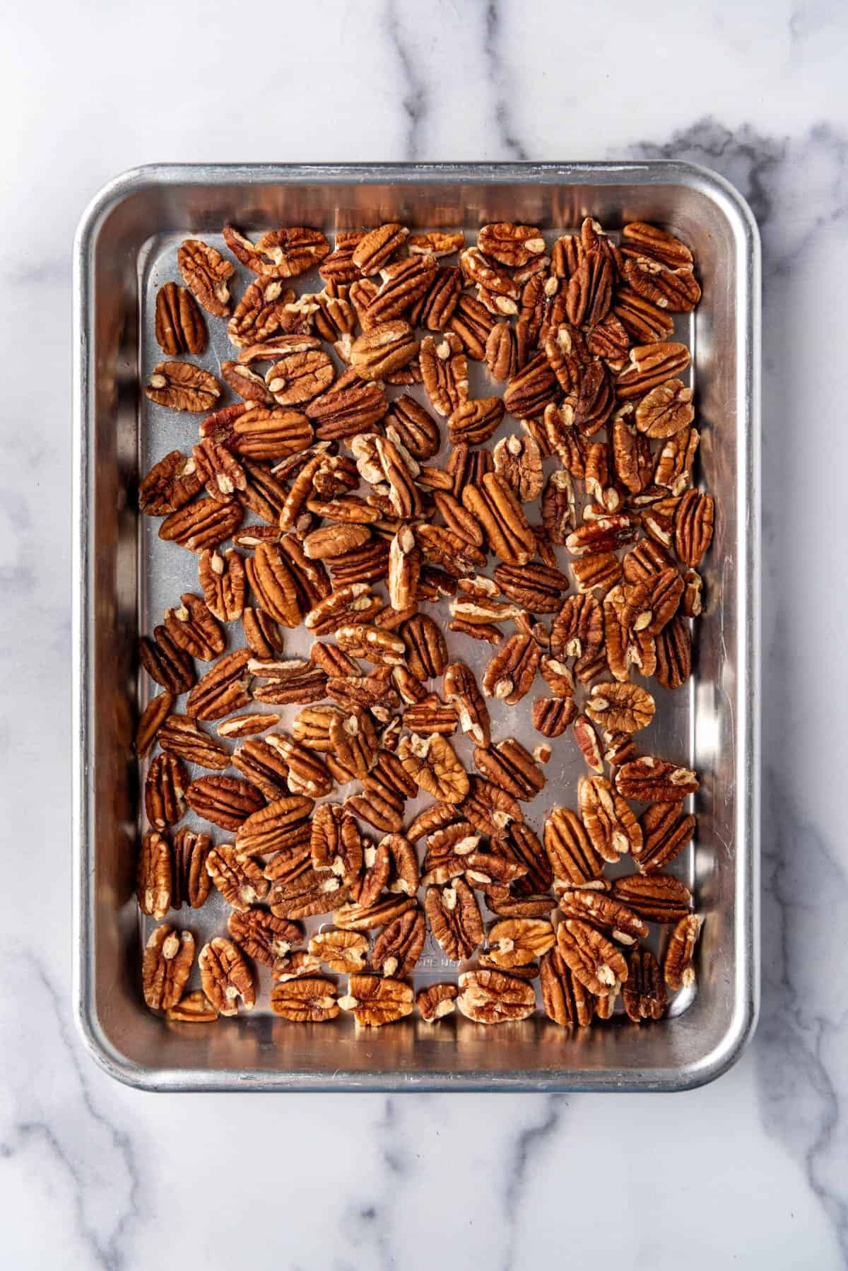 An image of toasted pecans on a baking sheet.