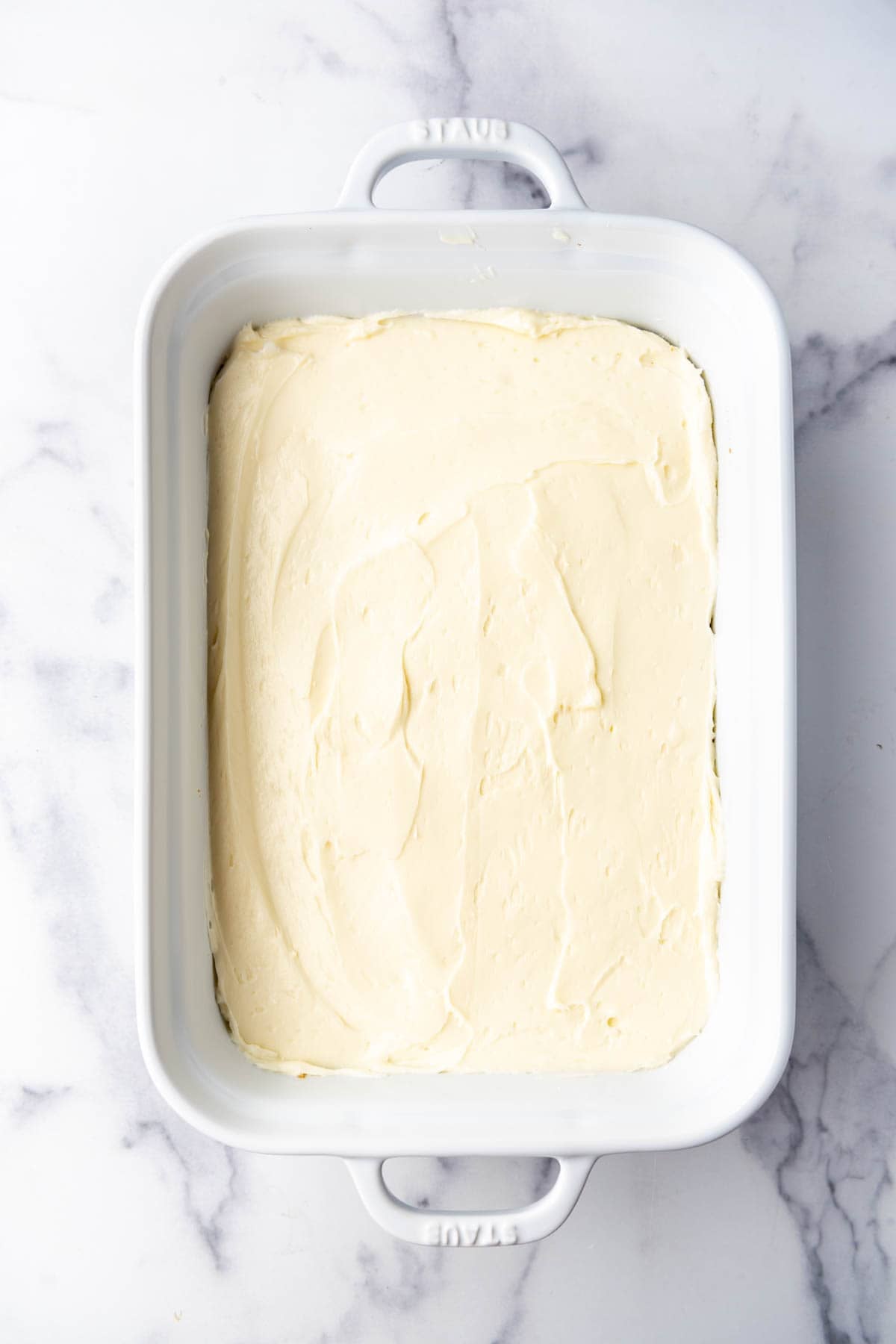 A cream cheese layer in a baking dish.
