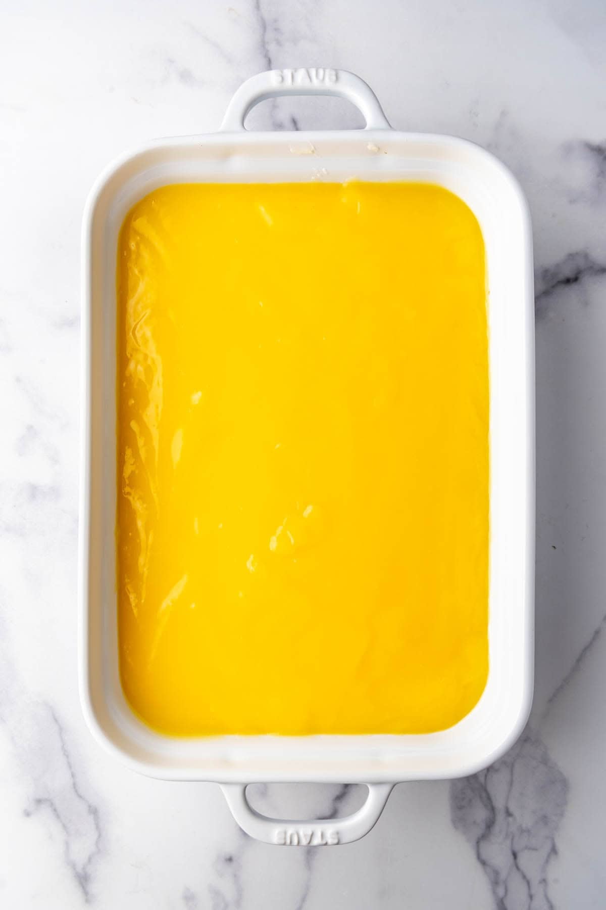 A lemon pudding layer in a baking dish.