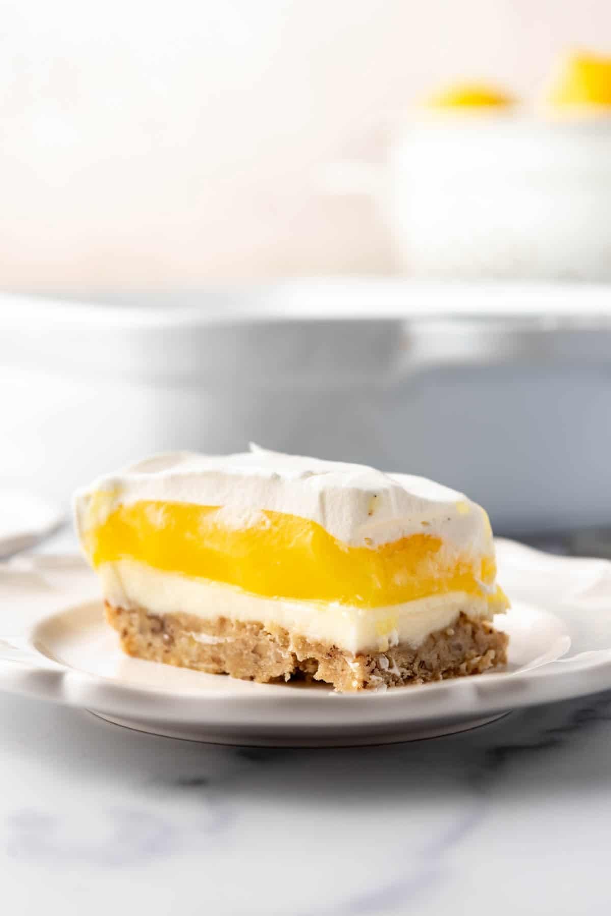 A slice of lemon lush on a white plate.