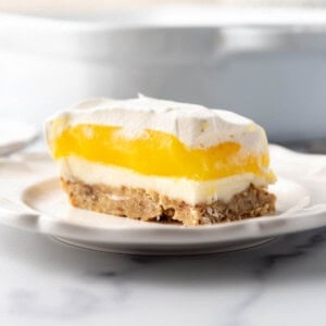 A slice of lemon lush on a white plate.