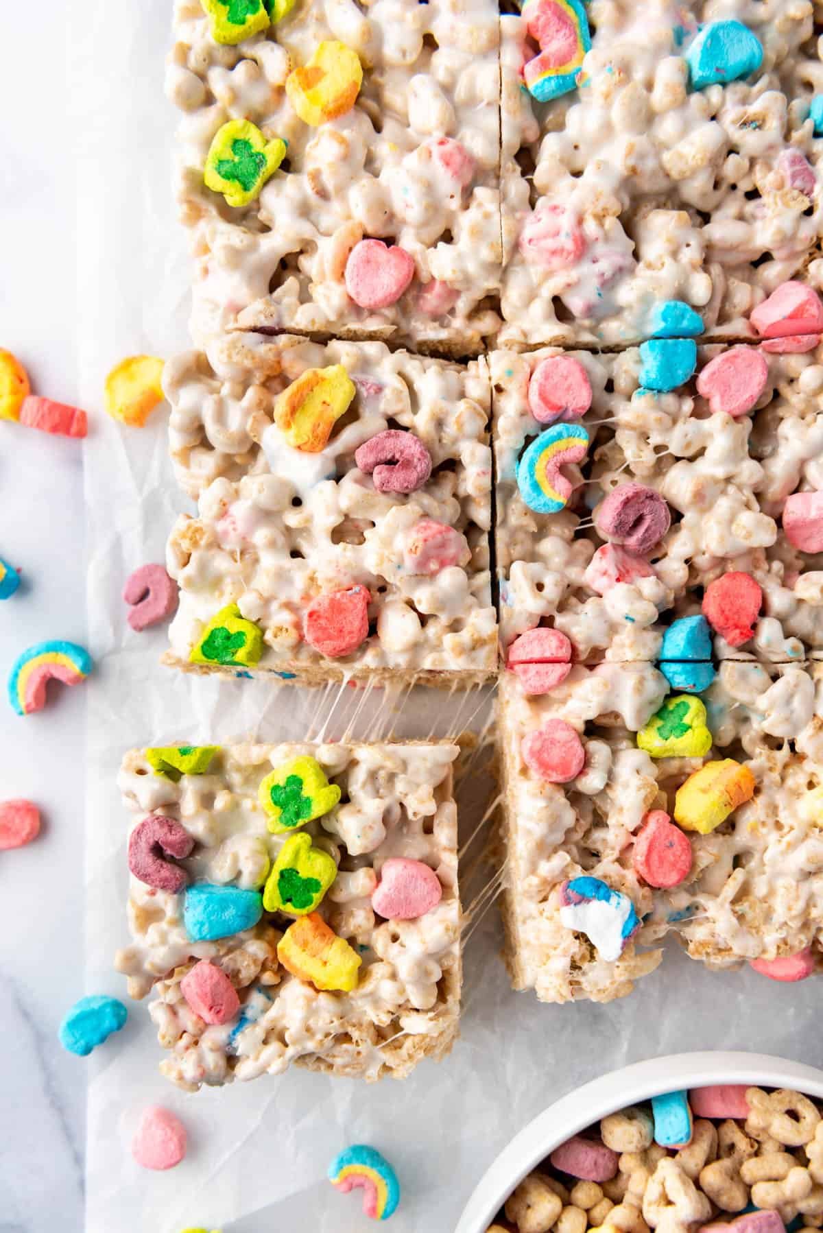 An overhead image of Lucky Charms rice krispies treats that have been cut into squares with one being pulled away from the others.