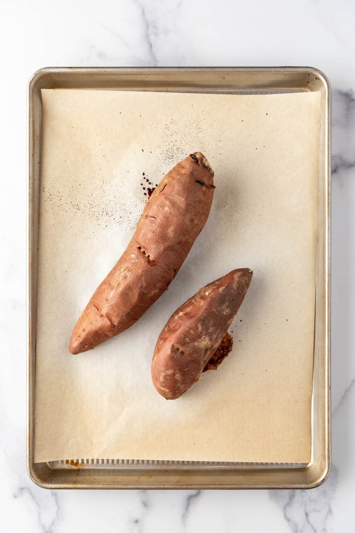 Baked sweet potatoes on a baking sheet.