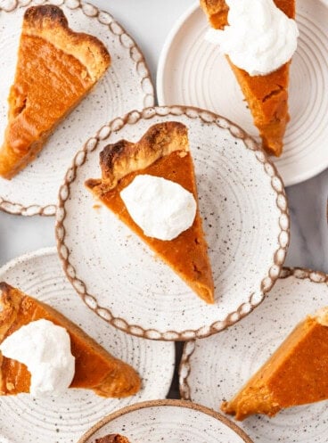 An overhead image of slices of sweet potato pie on overlapping plates.