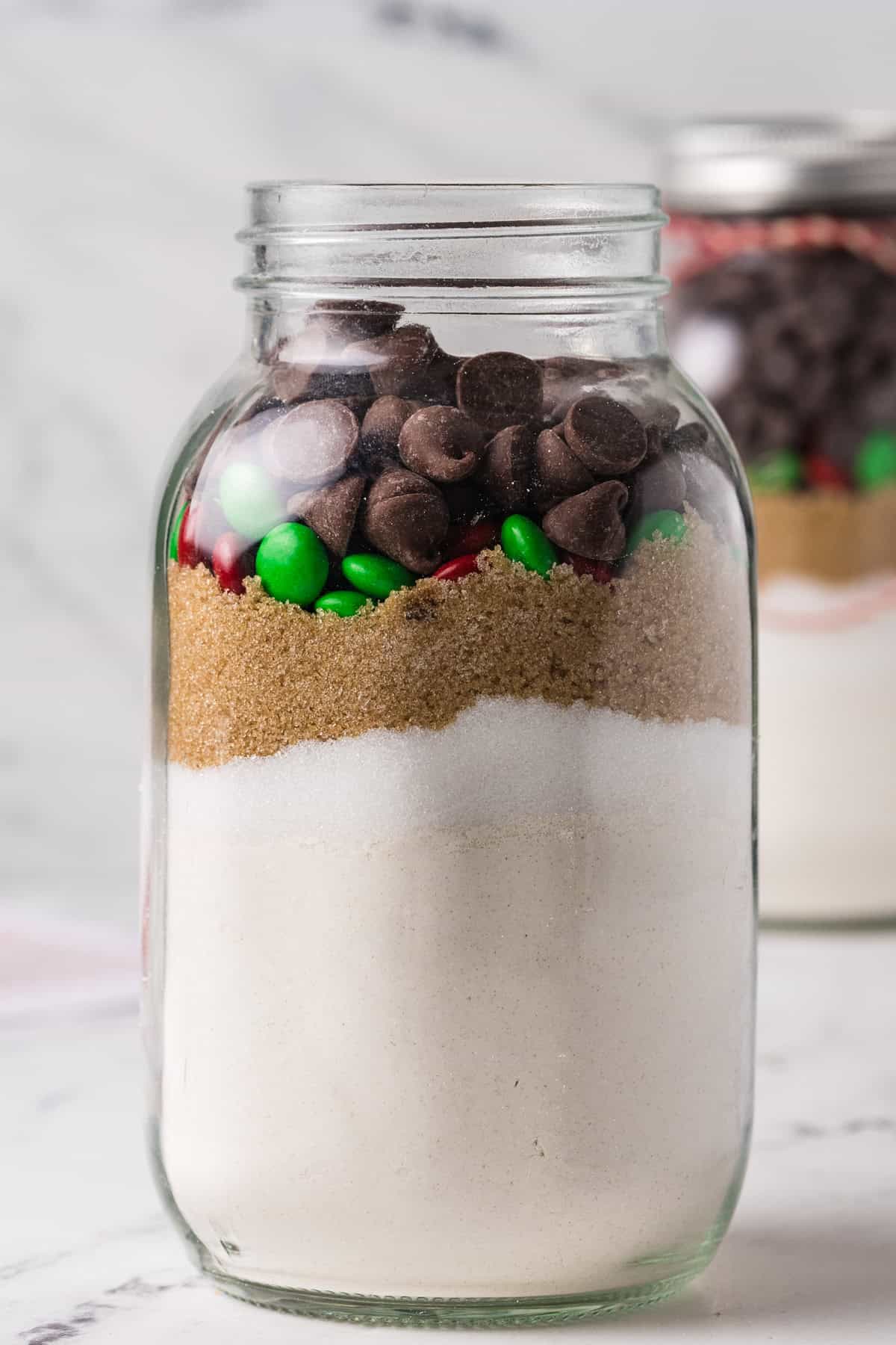 Layering ingredients for chocolate chip cookies in a jar.