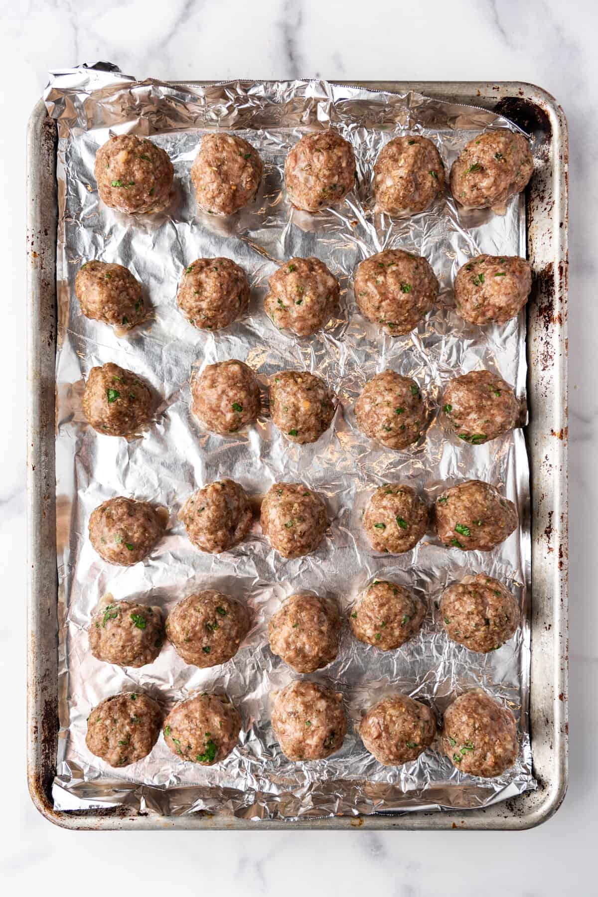 Baked meatballs on a baking sheet.