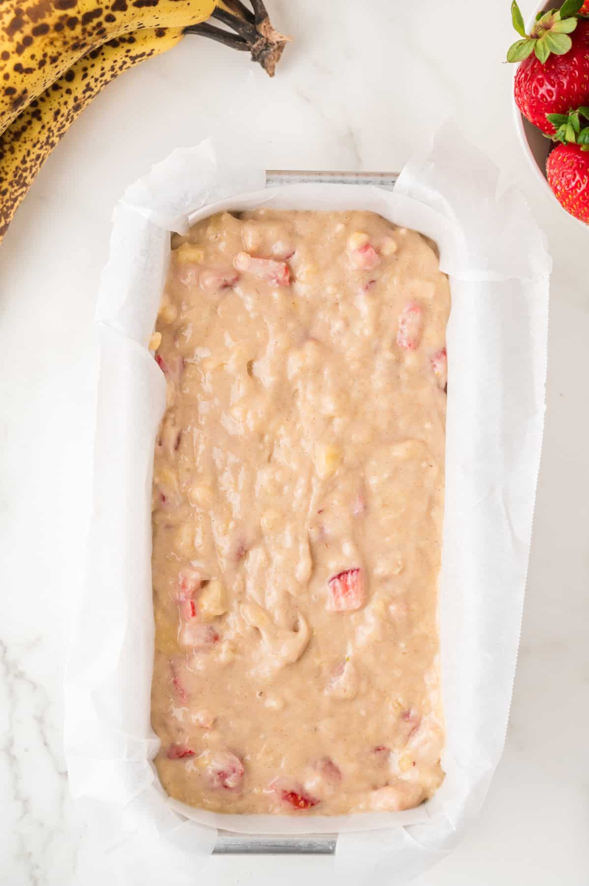 Strawberry banana bread batter in a loaf pan.