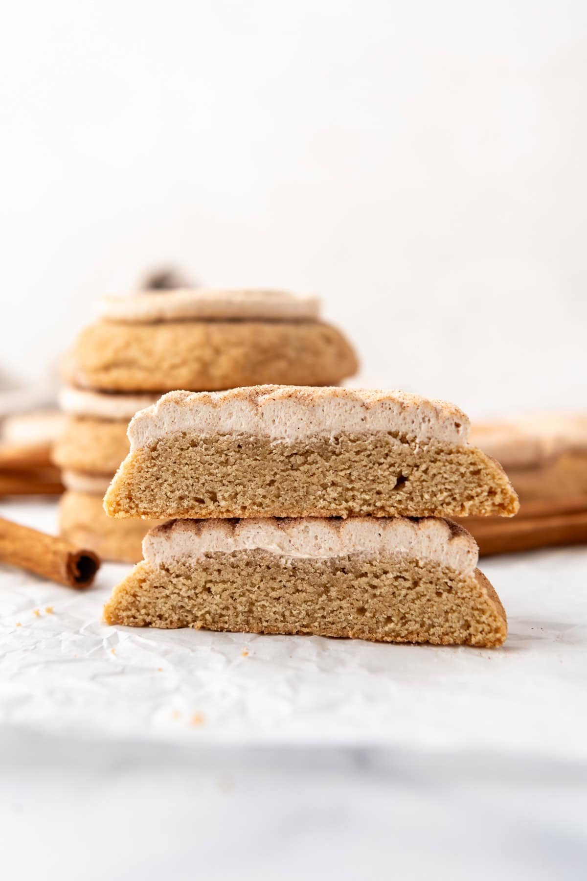 Frosted churro cookies with a cookie that has been cut in half and stacked.