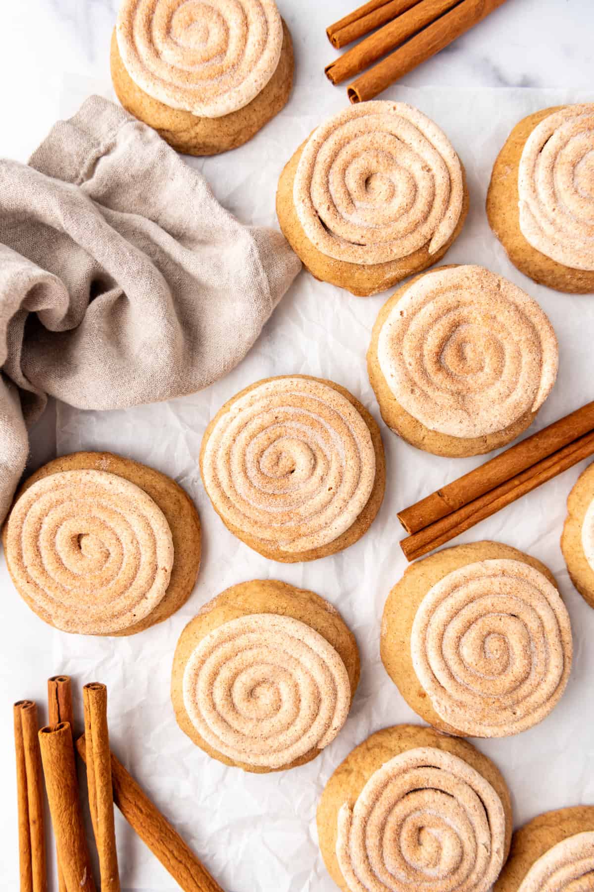 An overhead image of churro cookies next to cinnamon sticks.
