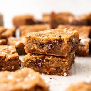 Two chocolate chip caramel bars stacked on top of each other.