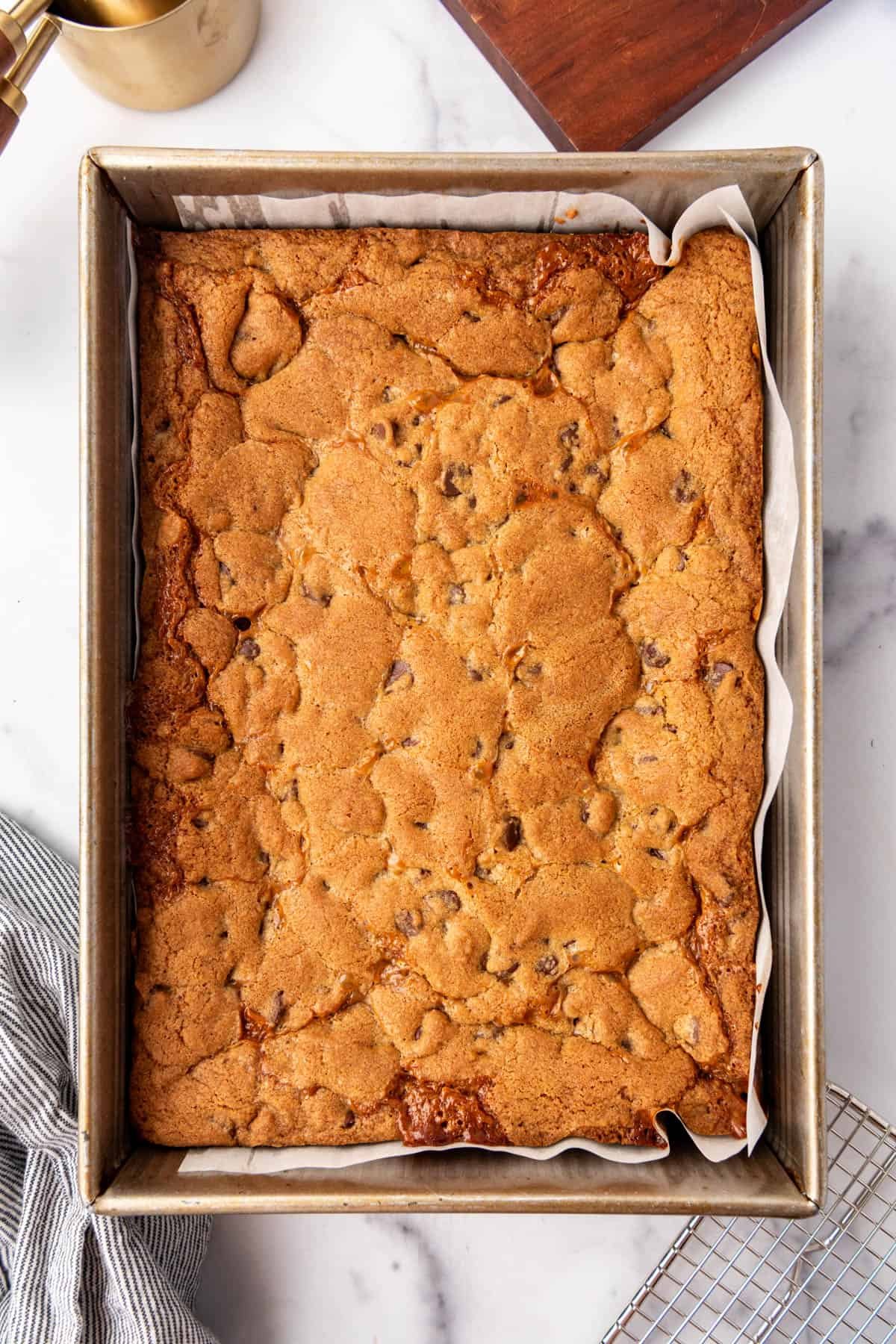 A 9x13-inch pan of baked chocolate chip caramel bars.