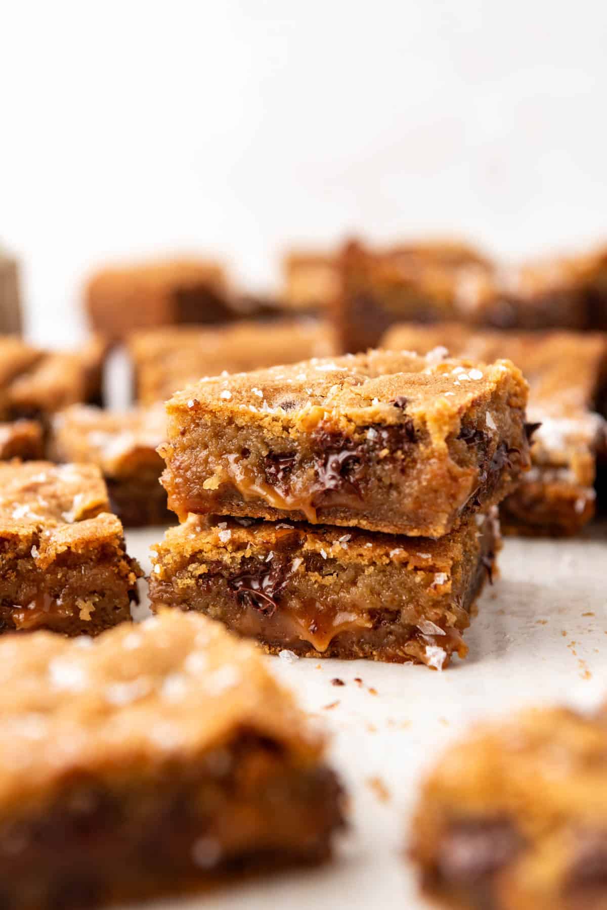 Two chocolate chip caramel bars stacked on top of each other.