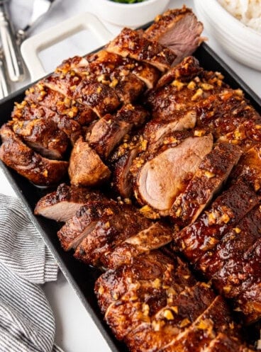 A serving platter loaded with sliced island pork tenderloin.