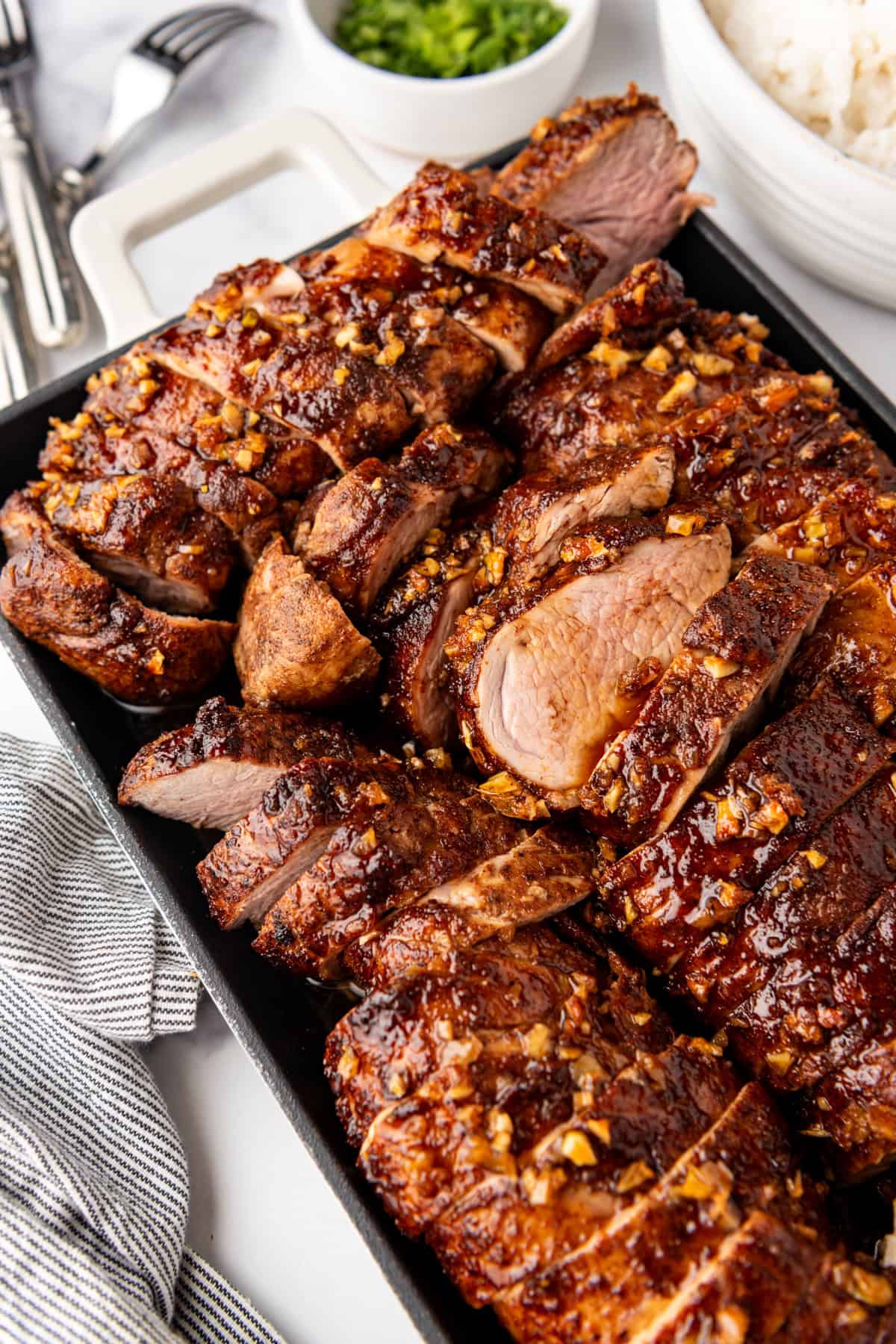 A serving platter loaded with sliced island pork tenderloin.