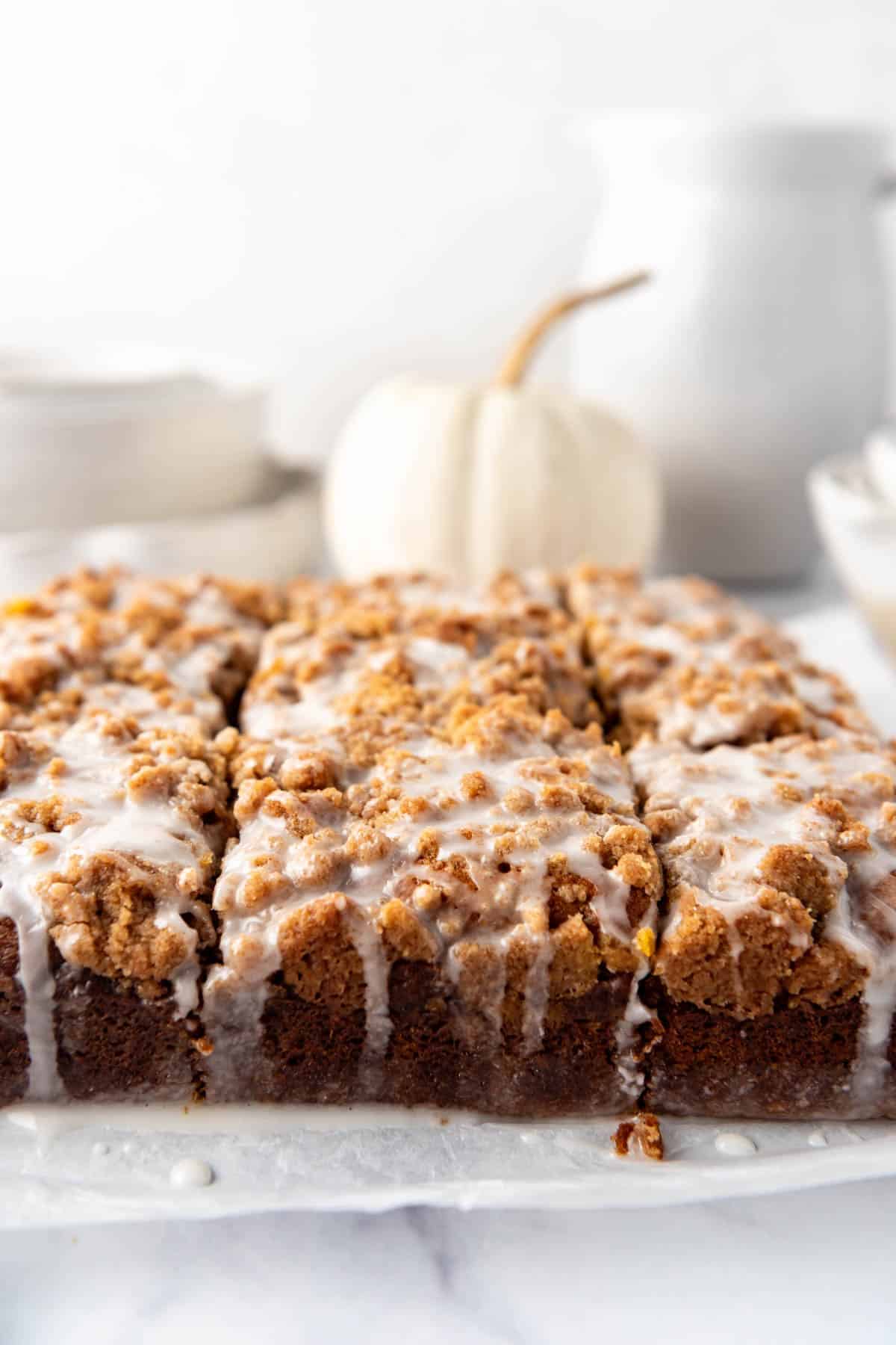 A side view of glaze dripping down the side of coffee cake.