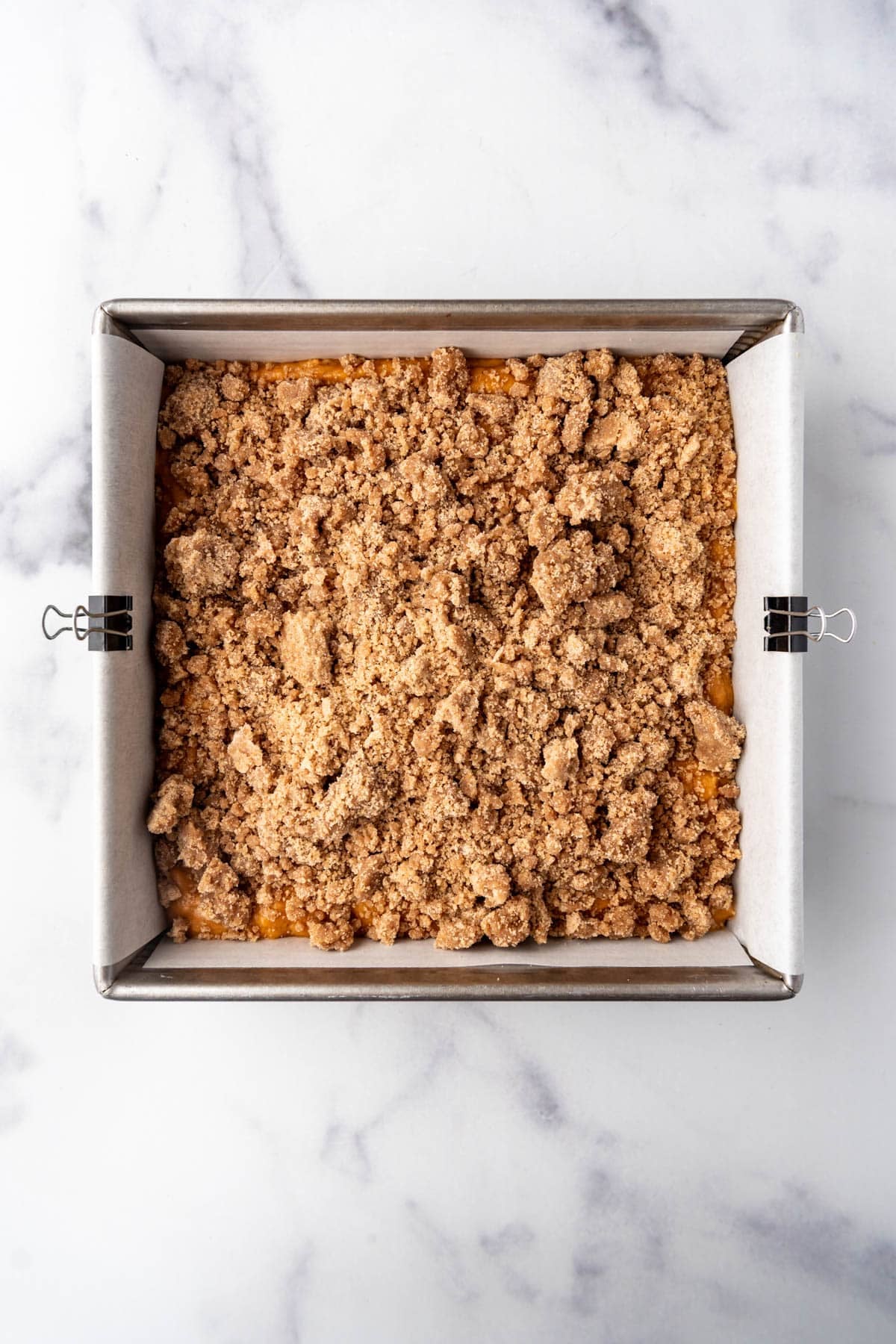 Pumpkin coffee cake with crumb topping ready to be baked.