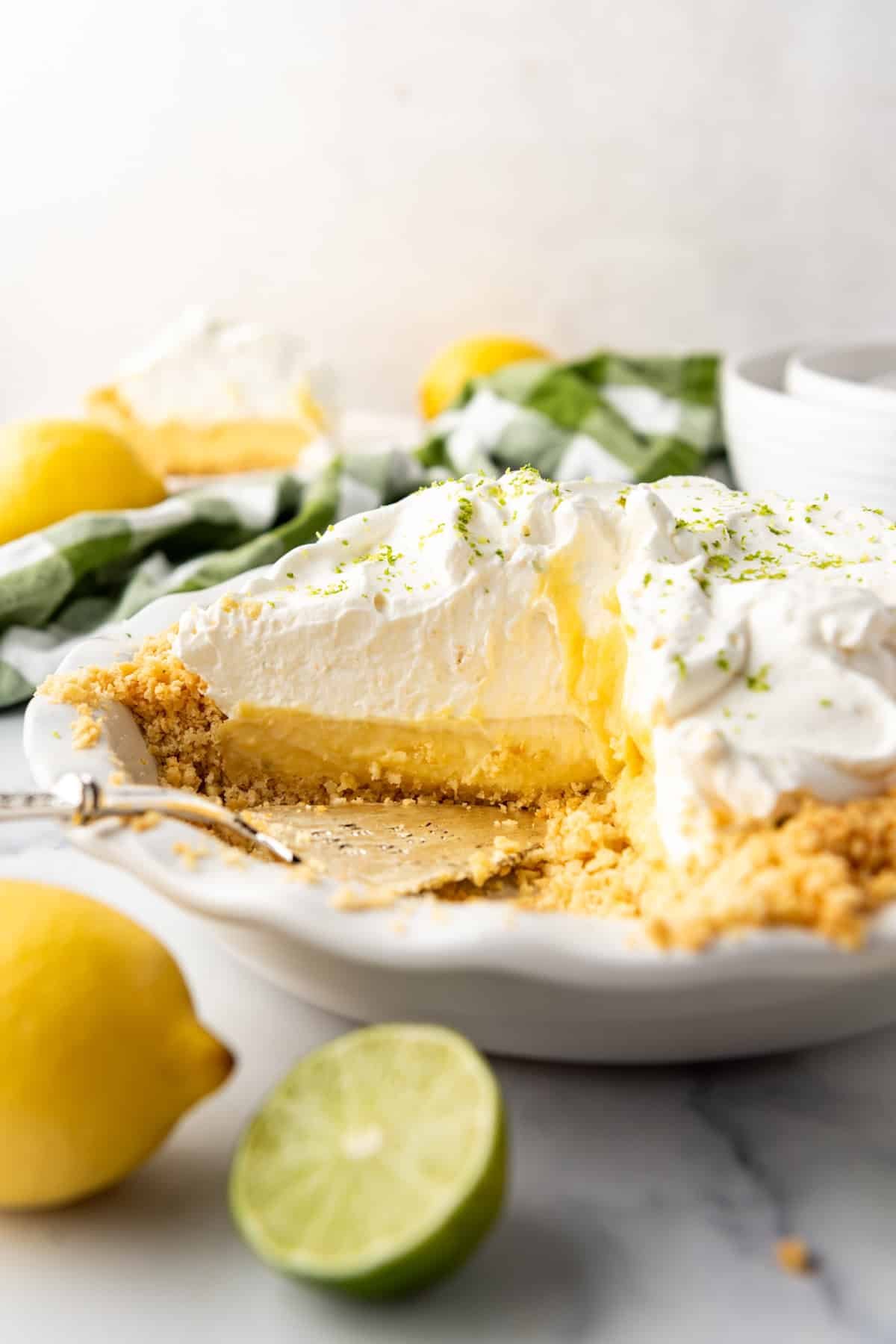 An image of a partially sliced Atlantic Beach pie with lemons and limes nearby. - 2